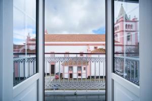 英雄港Açores Autêntico Boutique Hotel的从开放式窗户欣赏建筑景致