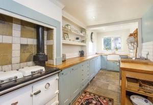约克Minster House - Group Hot Tub的一间设有蓝色橱柜和水槽的大厨房