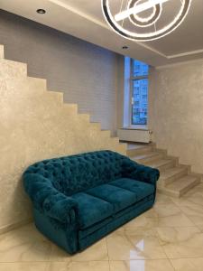 文尼察Holiday house的客厅设有蓝色沙发,设有楼梯