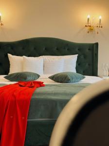 布拉索夫4Cardinal's Hotel Boutique的一间卧室配有一张大床和绿色床头板