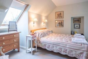 伍德布里奇Mole Cottage, Orford的一间卧室配有一张床、一个梳妆台和一扇窗户。