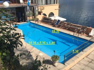 加尔达湖滨怡东酒店公寓的毗邻水面的大型蓝色游泳池