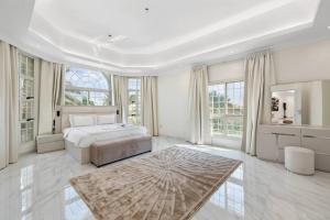 迪拜Luxury Emirates Private Villa in Dubai Jumeirah的白色的卧室设有床和大窗户