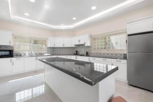 迪拜Luxury Emirates Private Villa in Dubai Jumeirah的一个带白色橱柜和大岛的大厨房