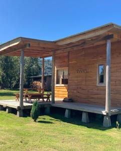 科查莫La Casona Puelo Lodge的小木屋设有门廊和野餐桌