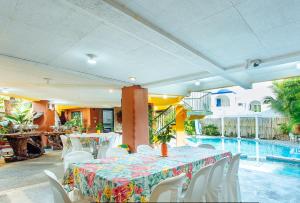 卡兰巴RedDoorz @ Yahweh Spring Retreat & Resort Laguna的一间带桌椅的用餐室和一个游泳池
