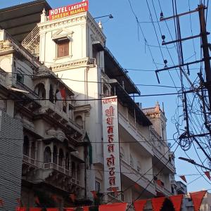 印多尔Hotel Lakshya Sheesh Mahal Indore的一座高大的白色建筑,上面有标志