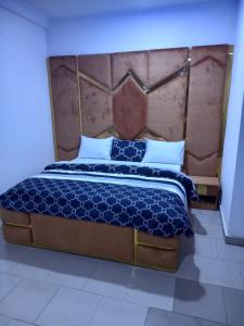 GwarinpaMega Pavilion Apartment And Suits Gwarinpa的一间卧室配有一张大床和大床头板