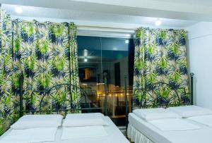 卡兰巴RedDoorz @ Yahweh Spring Retreat & Resort Laguna的客房设有两张床和一个带窗帘的窗户。