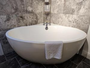 格拉斯米尔湖景乡间住宿加早餐旅馆的浴室设有白色浴缸,配有毛巾