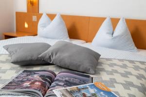 洛迦诺Hotel Rondinella Locarno的一本书坐在床上,上面有枕头