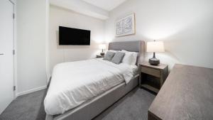 克利夫兰Landing Modern Apartment with Amazing Amenities (ID4770X14)的白色卧室配有床和平面电视