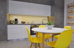 斯维诺乌伊希切Apartamenty Bryza - Debina的厨房配有桌子和黄色椅子