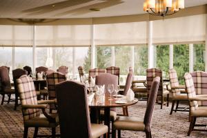 阿伯福伊尔Macdonald Forest Hills Hotel & Spa的用餐室设有桌椅和窗户。
