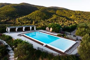 奥尔比亚Casagliana Suite Resort的享有游泳池的顶部景色,游泳池背景为群山