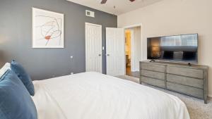 普莱诺Landing Modern Apartment with Amazing Amenities (ID8229X54)的一间卧室配有一张床和一台平面电视
