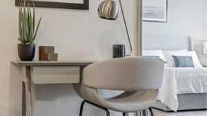 MiddleburgLanding Modern Apartment with Amazing Amenities (ID9574X29)的一张桌子和一张椅子,位于床边