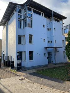 切尔滕纳姆Cosy Private Ensuites and Studios in the heart of Cheltenham的白色公寓大楼,拥有蓝色的外墙