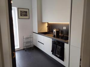 图斯卡尼亚LESS IS MORE的小厨房配有白色橱柜和水槽
