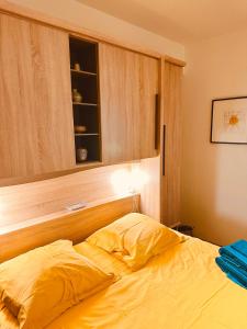拉莫赫莱Accueillant et pratique, proche de Chantilly et du parc Asterix的一间卧室配有一张黄色的床和橱柜