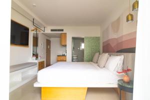 圣埃乌拉利亚Boutique Apartments Marsol Ibiza的卧室配有白色的床和电视