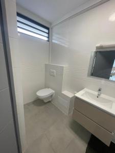 MontjolyLe refuge rafraîchissant的白色的浴室设有卫生间和水槽。