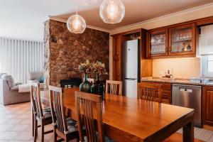 CastelejoA Nossa Casa的厨房配有木桌和冰箱。