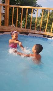 拉纳韦贝Belle Air Seaview (2 BDRM 2 King)的两名儿童在蓝色的游泳池玩耍