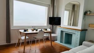 滨海卡约Appartement la capitainerie的客厅配有桌子和壁炉
