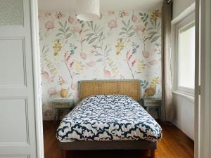 滨海卡约Appartement la capitainerie的一间卧室配有一张带花卉壁纸的床