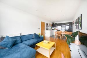 恩菲尔德Cozy and modern 1BR flat in Enfield的客厅配有蓝色的沙发和桌子