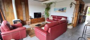 圣让-德吕兹Lodge Terre de Glisse的客厅配有2把红色椅子和桌子