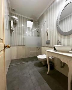 伊斯坦布尔暮烟套房酒店的一间带卫生间、水槽和镜子的浴室
