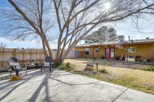 拉斯克鲁塞斯Quiet Country Home in Las Cruces with Horse Stalls!的一个带两把椅子的院子,一棵树和一所房子