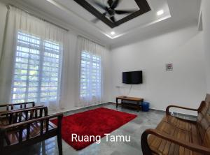 Gemia Rumah Tamu - 3 bilik aircond - near nasi dagang Atas tol的一间客厅,配有红色地毯和电视
