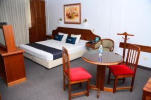 齐克拉约GLORIA PLAZA HOTEL的酒店客房带一张床、一张桌子和椅子