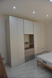 泰尔莫利Appartamento Cantralisimo的白色卧室配有白色橱柜和1张床