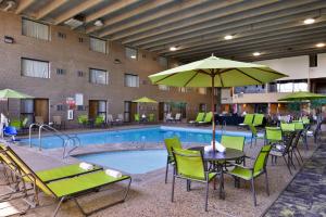 圣克劳德贝斯韦斯特凯利普乐斯凯丽酒店的酒店游泳池设有桌椅和遮阳伞