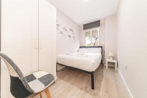 马德里Elegant 6 pax apartment in Plaza Eliptica - SM17的一间卧室配有一张床和一把椅子