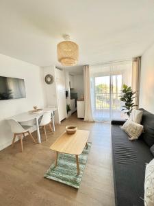 阿格德角Appartement Cosy - Cap d'Agde proche plage et port - Parking的客厅配有沙发和桌子