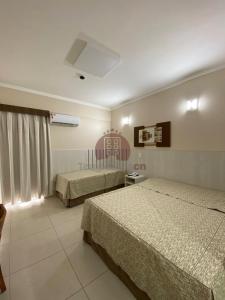 卡达斯诺瓦斯Spazzio diRoma com acesso ao Acqua Park - Adriele的酒店客房设有两张床和窗户。