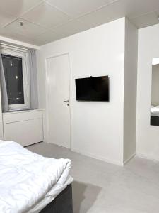 斯德哥尔摩Nomad Gardet的白色卧室配有床和平面电视