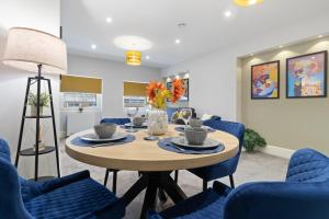 伍斯特WhiskAwayStays - Victoria House - Apartment 5的一间带桌子和蓝色椅子的用餐室