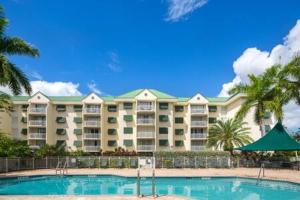 基韦斯特The Trinidad by Brightwild-Pool & Parking的一座大型公寓楼,设有游泳池和棕榈树