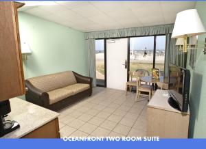 弗吉尼亚海滩帆船旅馆的带沙发的客厅和带阳台的客房。