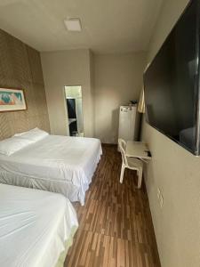 福塔莱萨Pousada da Celma的酒店客房设有两张床和一台平面电视。