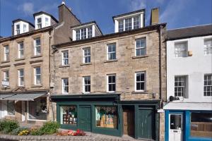 杰德堡Apartment in Scottish Borders的一座古老的砖砌建筑,前面有商店