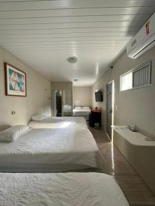 福塔莱萨Pousada da Celma的酒店客房设有两张床和盥洗盆