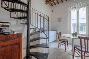 拉文纳La Casetta nel Cerchio的客厅里螺旋楼梯,配有桌子
