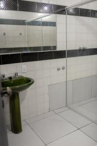 蒙蒂斯克拉鲁斯HOTEL VILAS DOS MONTES的一间带绿色水槽和玻璃淋浴的浴室